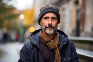 Handsome middle aged man with hat and scarf in the city