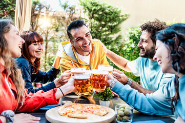 Happy friends enjoying happy hour at home garden - Group of young people drinking beer at bar restaurant patio - Friendship concept with guys and girls drinking and eating pizza together