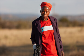 village african old woman cleaning the trash community service environment