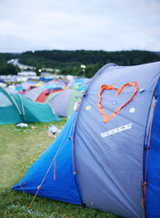 Camping, festival and heart on tent at evening outdoor for event, party or celebration in nature....