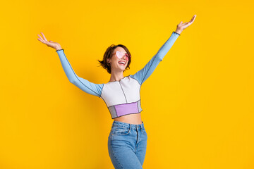 Photo of pretty impressed woman wear top pink glasses rising arms looking empty space isolated yellow color background - obrazy, fototapety, plakaty