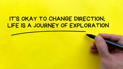 Hand writing It is okay to change direction affirmation on yellow cover background. Affirmation...