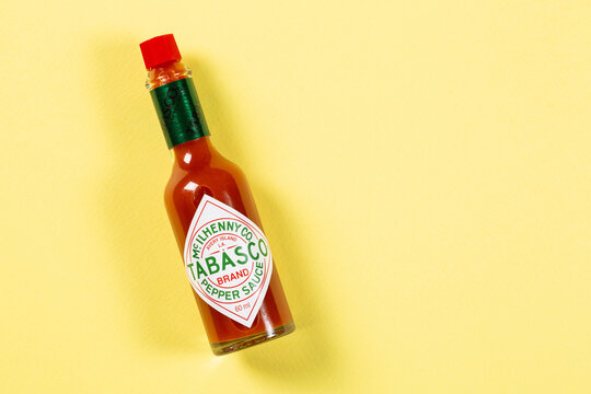 A bottle of Tabasco pepper sauce on yellow background