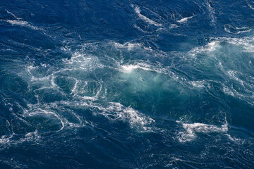 The Saltstraumen maelstrom churns the ocean into a beautiful, textured canvas of swirling blues and...