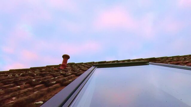 Dachfenster mit sich spiegelnden Wolken die Abends im Zeitraffer vorbeiziehen, rote Ziegel, Dachd&auml;mmung
