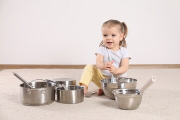 Cute little girl with cookware at home