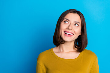 Photo of excited dreamy woman wear shirt smiling looking empty space isolated blue color background