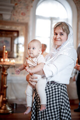 a mother with a small child in an Orthodox Christian church or temple prays or came to the...
