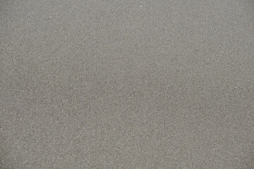 Sea sand closeup flat lay. Sea sand top view flat lay. Gray sea sand on the seashore.