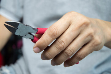 Mechanic holds red handle cutting pliers, mechanic's tools