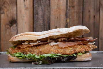 Gourmet sandwich. Closeup view of a multilayer sandwich with chicken fried steak, bacon, cheese and lettuce. 
