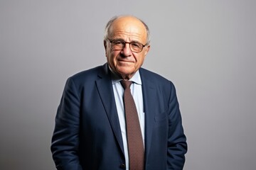 Portrait of a senior business man with eyeglasses on grey background