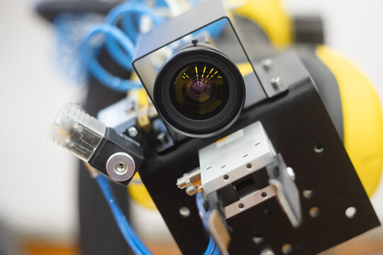 Machine vision. The robot is staring at the viewer. The manipulator arm uses a camera to observe and control objects and communication with a person.