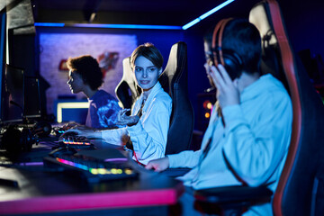focus on smiling woman with short hair giving advice on game strategy to female player near monitor
