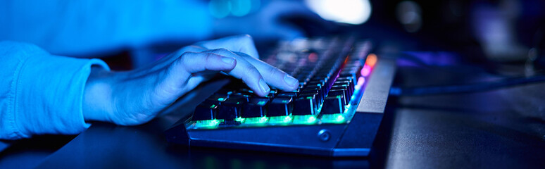banner of cropped female hands typing on computer keyboard with illumination, blue light - obrazy, fototapety, plakaty