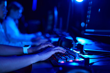 cropped photo of female hands, young gamer using computer keyboard while playing game, cybersport
