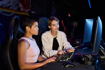 Fototapeta na wymiar two women focused on a cybersport gaming session, young players thinking on game strategy