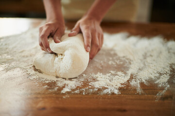 Hands, dough and wheat flour on kitchen counter at bakery, bread or pizza with meal, catering and...