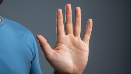 a person wearing blue shirt saying stop using his hand