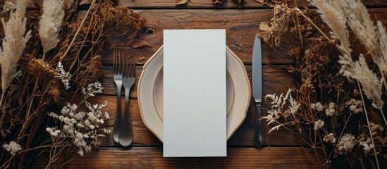 Top view of boho wedding place card mockup with blank white paper, fork, knife, and bohemian decor...