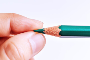 Hand holding a green pencil, business economy financial concept