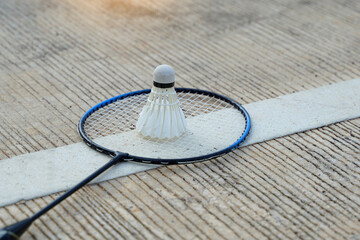 Badminton racket and white shuttlecock placed on green cement background. soft and selective focus. 