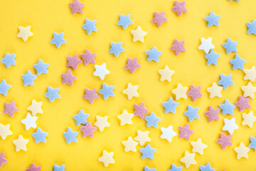 Colorful sugar sprinkles on yellow background