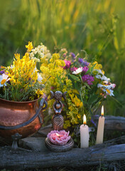 wiccan Goddess Candlestick, Copper witch cauldron with flowers, magic things, candles on meadow,...