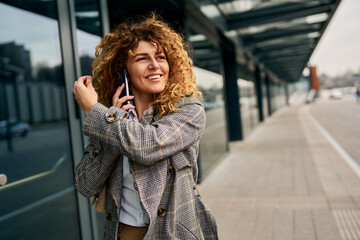 A successful and pretty businesswoman, dressed in casual attire, exits the railway station with...