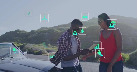 Animation of energy and ecology icons over happy diverse couple by car on road trip - Powered by Adobe