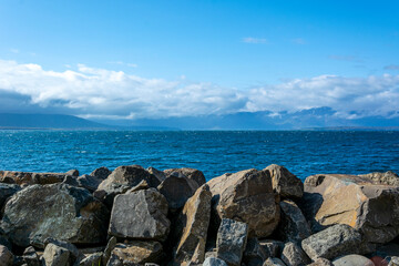 Fototapeta na wymiar rocks on the beach calm landscape of blue ocean and clouds sky