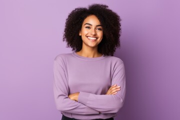 Portrait of smiling african american woman with crossed arms on violet background