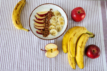 Zdrowe śniadanie z jogurtem naturalnym, granolą, jabłkiem i bananami © Monika