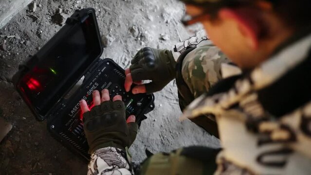  Man enters code in case with time-bomb for playing lasertag game