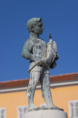 Obraz premium Boy with Fish fountain on Marshal Tito Square in front of Tower with city clock, Rovinj, Croatia