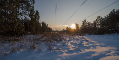 Zachód słońca w zaśnieżonym lesie - słupy elektryczne na polanie ( przecince) iście epicki i malowniczy widok. Piękno przyrody polskiej w okolicach Ostrowca Świętokrzyskiego
