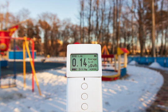 Measuring radiation using a modern dosimeter radiometer. Monitoring dangerous ionizing radiation outdoors in a city park or playground. Radiation safety control. Soft selective focus