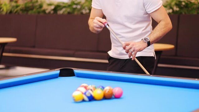 Male hands rub cue with chalk before pool game, slow motion, noface