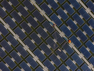 Worker Cleaning  floating solar panels or solar cell Platform system on the lake with brush and...