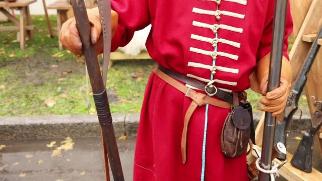 Close-up of man torso in uniform of russian sagittarius with an poleaxe and gun, slow motion