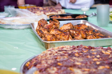 grilled Chicken tray ready to be eaten with people hands and musakhan bread