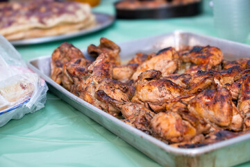grilled Chicken tray ready to be eaten with people hands and musakhan bread
