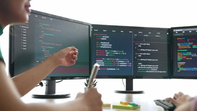 Back end software developer engineer for computer programming working together on debugging writing computing code, solving complex algorithms display on monitor in office. Burgeoning
