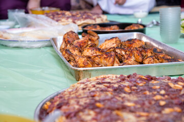 grilled Chicken tray ready to be eaten with people hands and musakhan bread