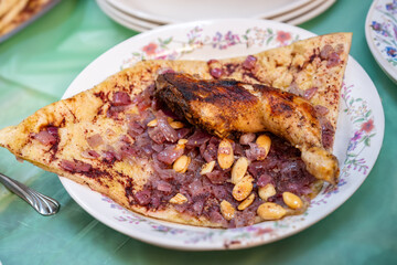 Plate of chicken and musakhan bread on green background