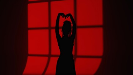 Modern dance choreography. Female silhouette of dancer dancing against window shade. Woman in...