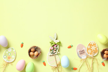 Happy Easter card. Flat lay Easter eggs, decorations, nest with eggs on green background. Top view.
