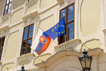Slovakia flag and EU flag on the wall of a house. Flags in the facade of old building. Slovakia is...