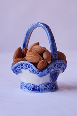 Beautiful background with raw almonds in a porcelain basket

