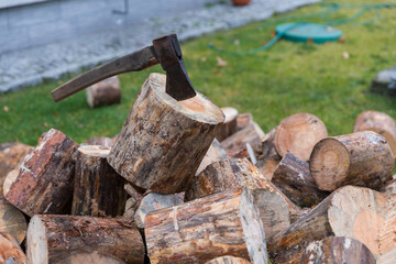 An ax for splitting firewood stuck into a stump for chopping wood.